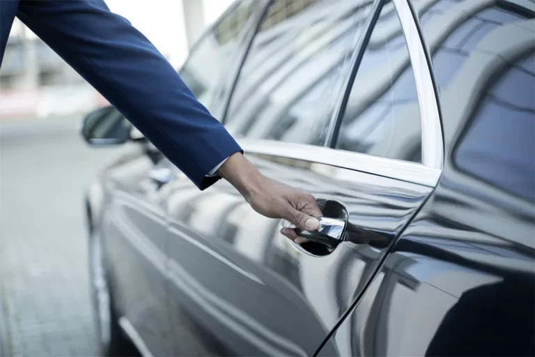Driver opening the door of a black private car