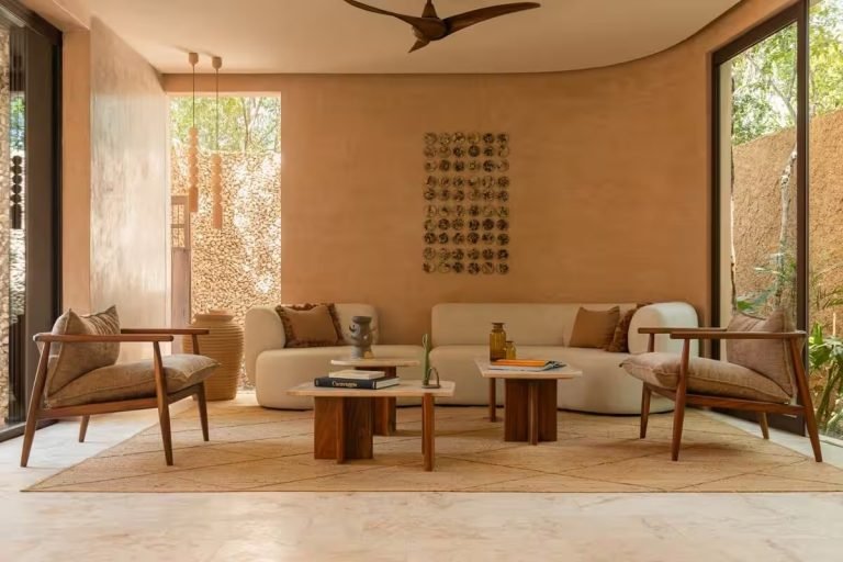 Open-plan living room with rattan armchairs and a low table at Piece of Heaven villa in Tulum