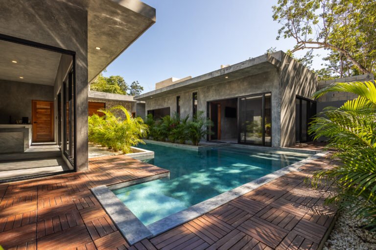 Turquoise pool and wooden deck framed by jungle at Casa Santo, a four-bedroom villa sleeping ten in Tulum