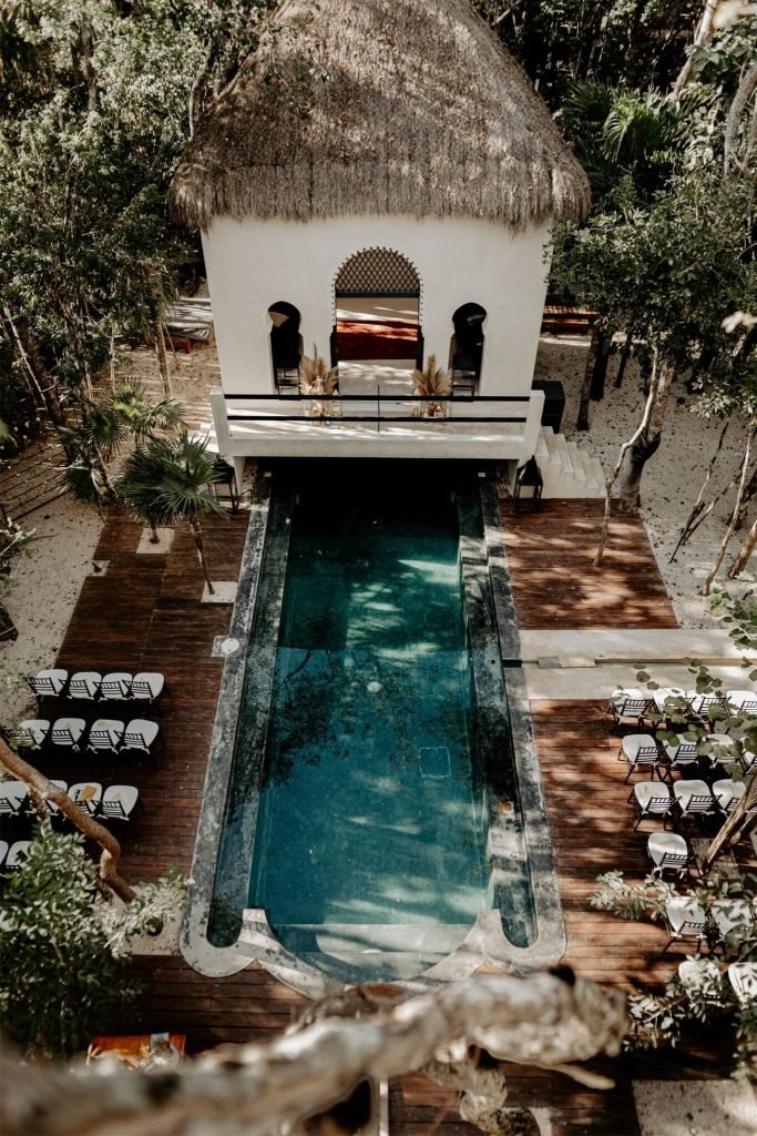 Jungle wedding venue in Tulum: ceremony chairs set either side of a villa pool under the canopy